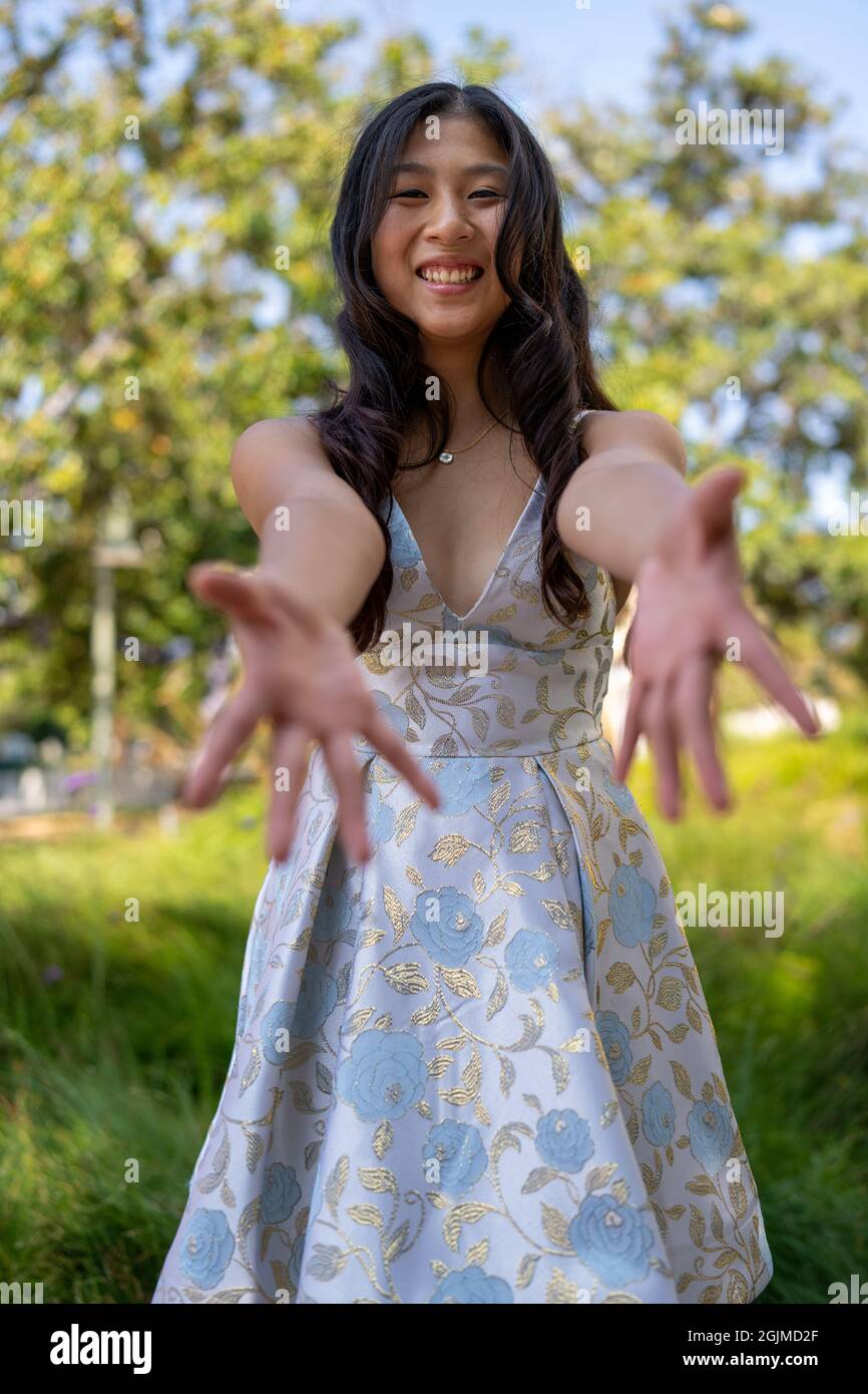 Ragazza asiatica adolescente che raggiunge le mani d'aiuto Foto Stock