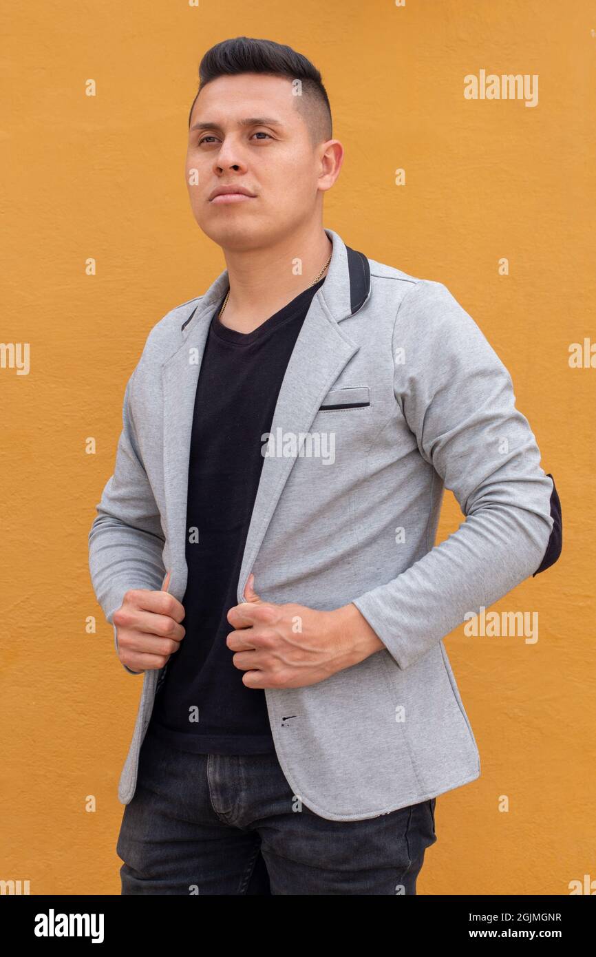 Uomo latino che indossa un blazer grigio, uomo che indossa abiti. Concetto di spazio di copia Foto Stock
