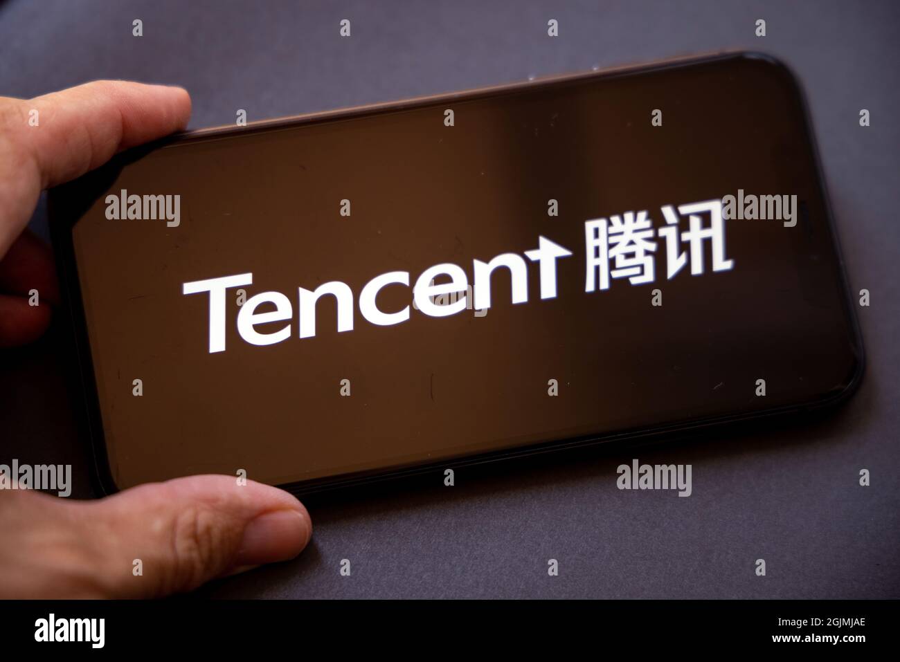 Tencent Holdings Ltd. È una holding multinazionale cinese di conglomerati tecnologici. Uno smartphone con il logo Tencent in una mano. Foto Stock