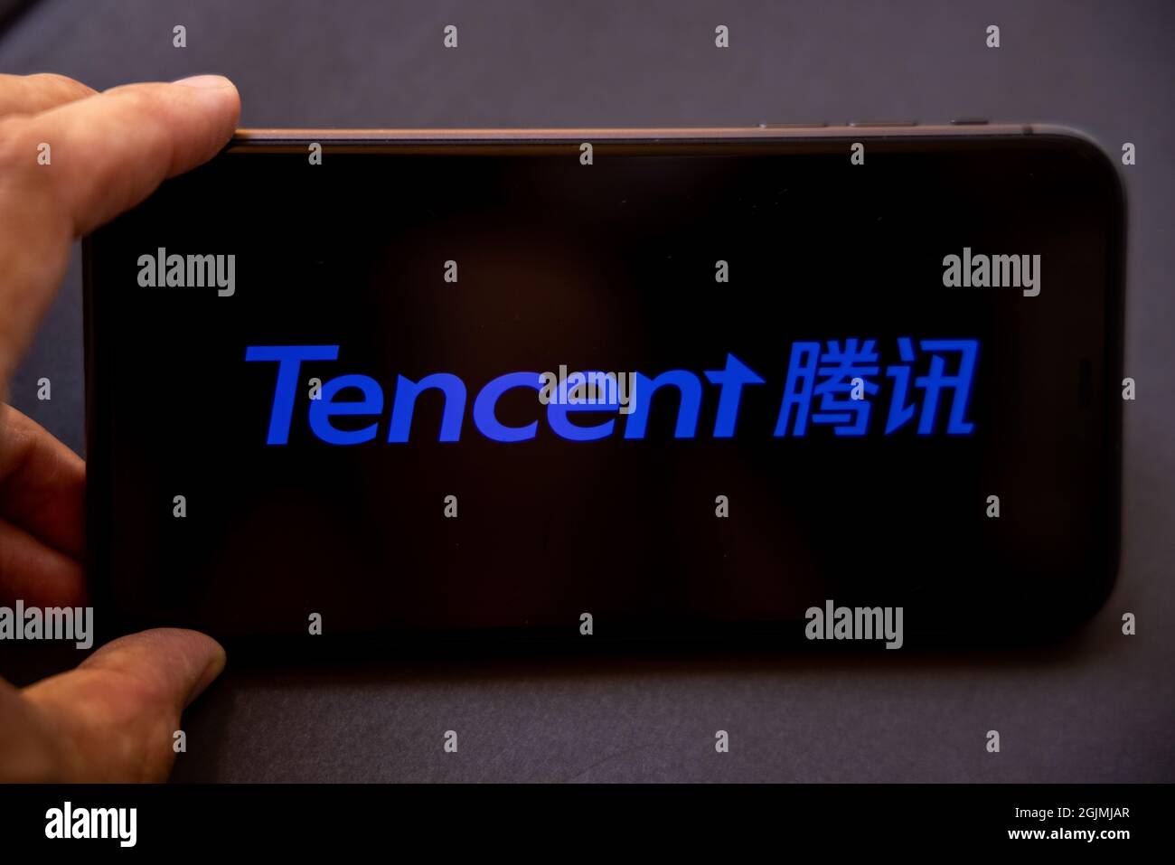 Tencent Holdings Ltd. È una holding multinazionale cinese di conglomerati tecnologici. Uno smartphone con il logo Tencent in una mano. Foto Stock