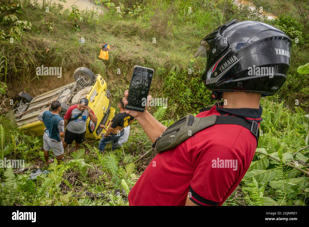 Kendari, Indonesia. 11 Settembre 2021. Un residente prende una trasmissione video dal vivo del processo di evacuazione per i social media.A veicolo crashed giù il burrone tuttavia nessuno ha sostenuto lesioni. Si sospetta che l'incidente sia stato causato da un conducente assonnato. (Foto di Andry Denisah/SOPA Images/Sipa USA) Credit: Sipa USA/Alamy Live News Foto Stock