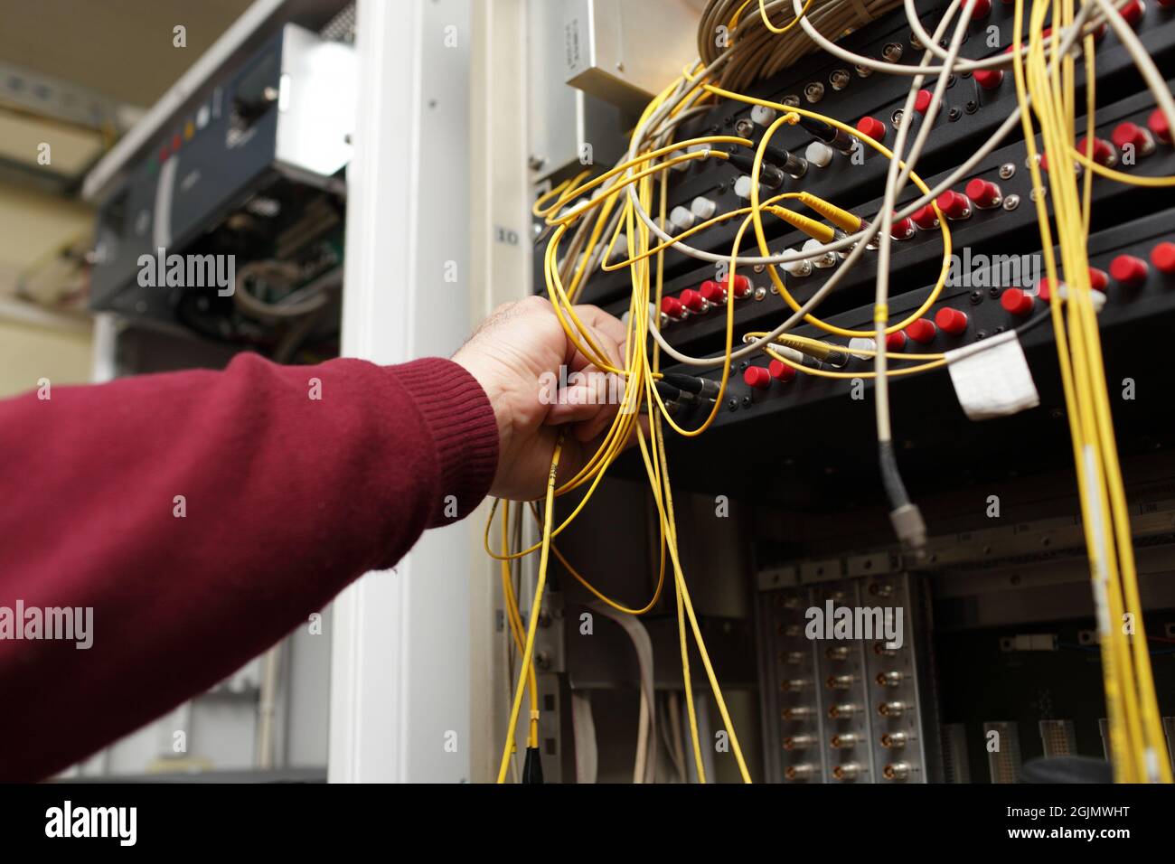 Il tecnico che collega la fibra ottica su ODF nel sito delle telecomunicazioni Foto Stock