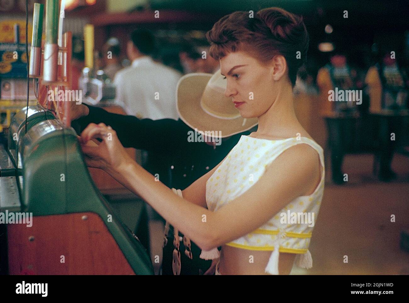Las Vegas 1959. Giovane donna a una slot machine. Una macchina in cui si mette in una moneta e tirare una leva che inizia la rotazione di tre rotoli. Una volta che si fermano e i tre mostrano lo stesso simbolo, si vince. Kodachrome vetrino originale. Credit Roland Palm Ref 6-2-16 Foto Stock
