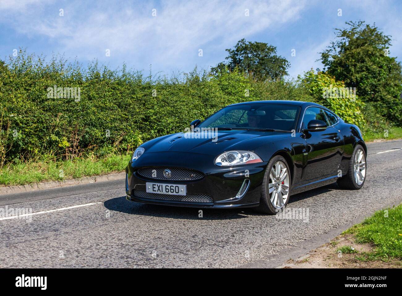 2010 Black British Jaguar XKR V8 R 2dr 6 velocità automatica coupé lungo il tragitto per Capesthorne Hall classica mostra di luglio, Cheshire, Regno Unito Foto Stock