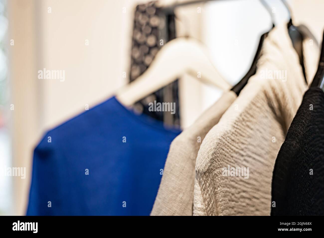 Abbigliamento elegante da donna alla moda su un appendiabiti. Primo piano di abbigliamento di marca in uno show room. Sfondo chiaro. Negozio di moda, show room, shopping o Foto Stock