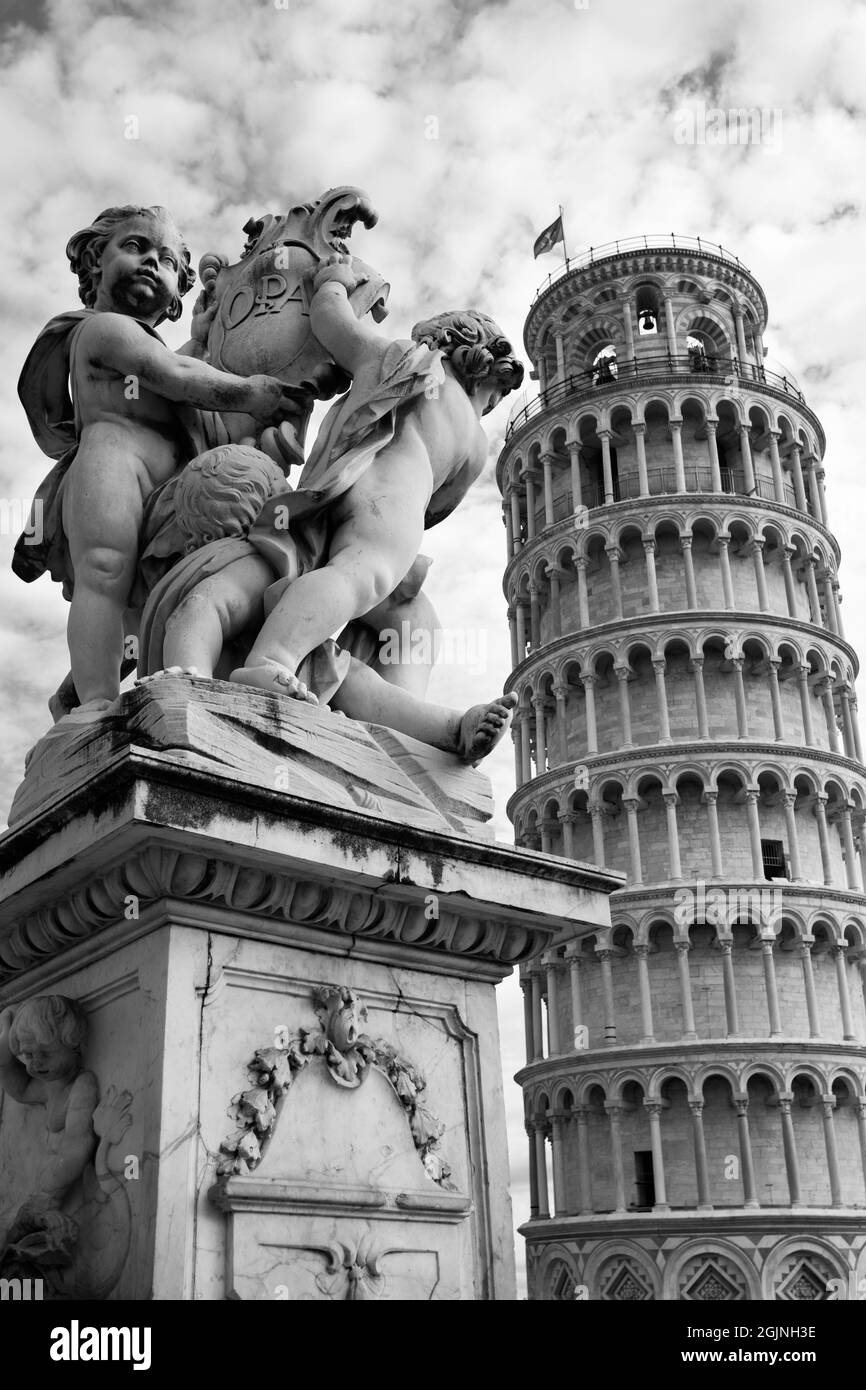 La Torre Pendente di Pisa e gli angeli di scultura sulla vecchia fontana, Italia. Fotografia in bianco e nero Foto Stock