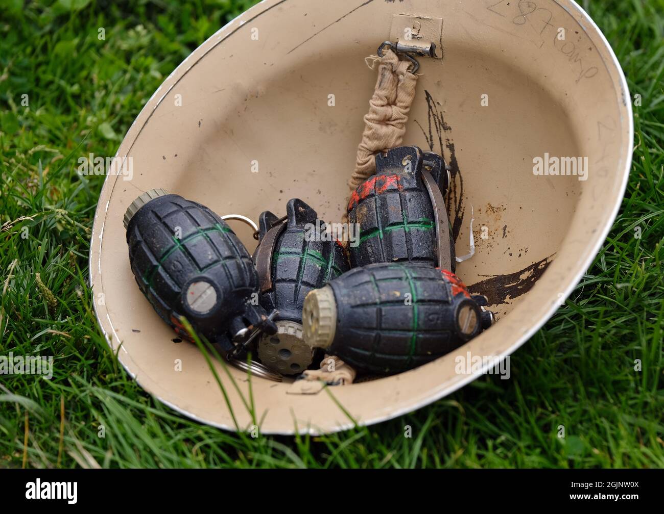 I mulini britannici bombardano le granate a mano in un casco da soldati. Foto Stock