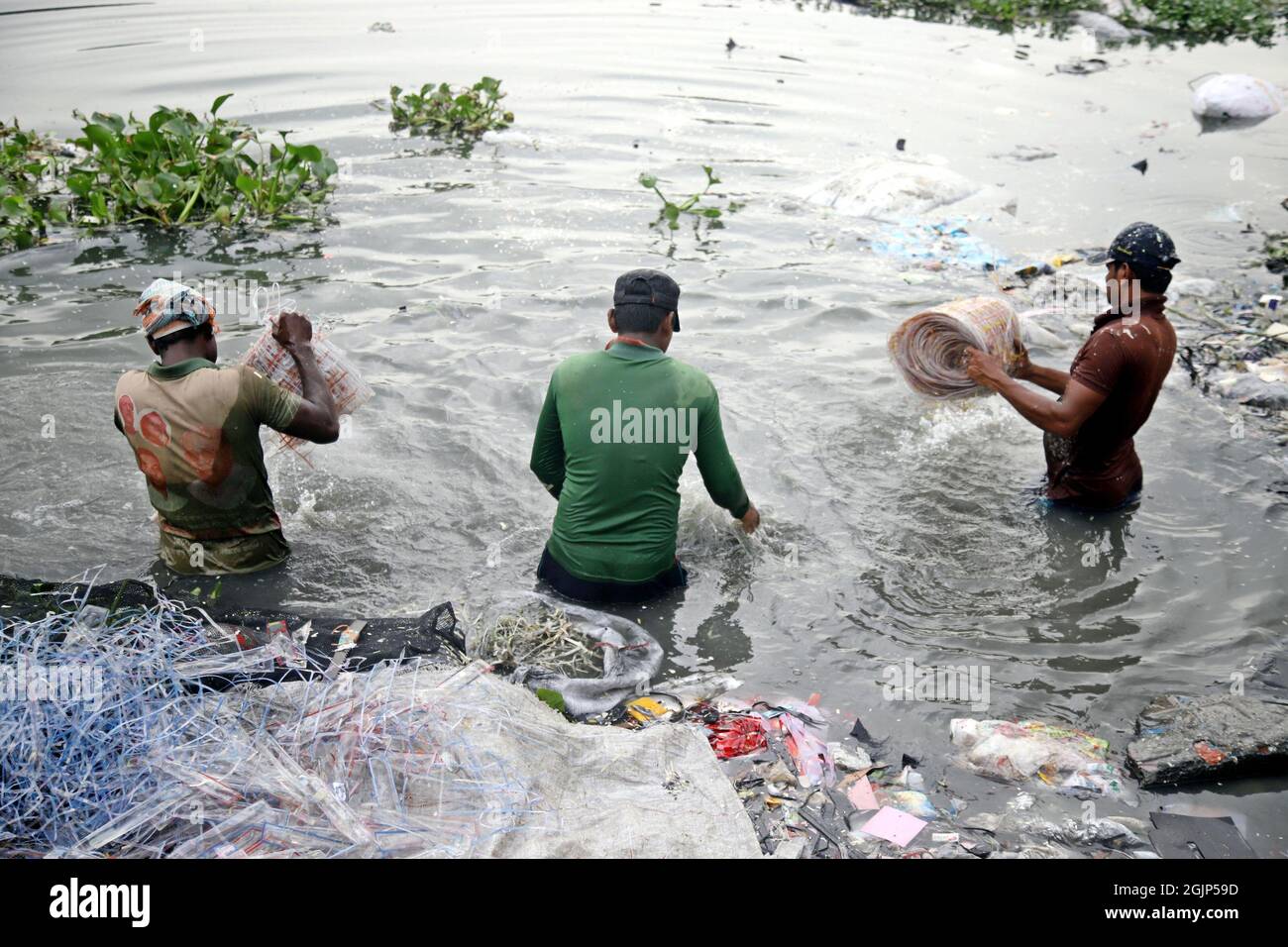 Non esclusiva: CITTÀ DI DHAKA, BANGLADESH, 9 SETTEMBRE: I lavoratori hanno battuto l'acqua di stoffa lungo un fiume inquinato. I lavoratori lavano, squillano fuori e asciugano il panno alon Foto Stock