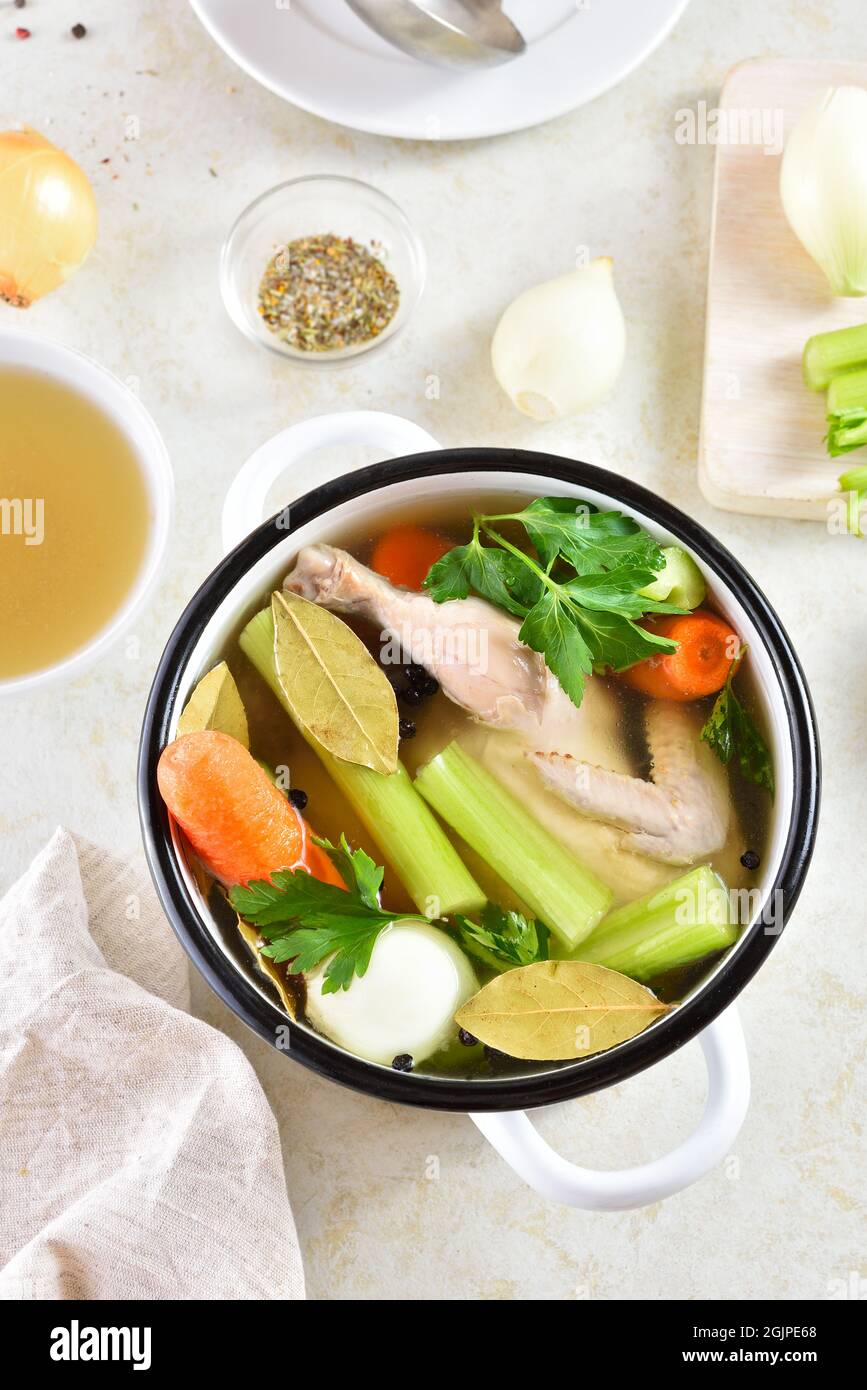 Brodo di pollo con verdure e spezie su sfondo di pietra chiaro. Piatto dietetico sano per cena. Vista dall'alto Foto Stock