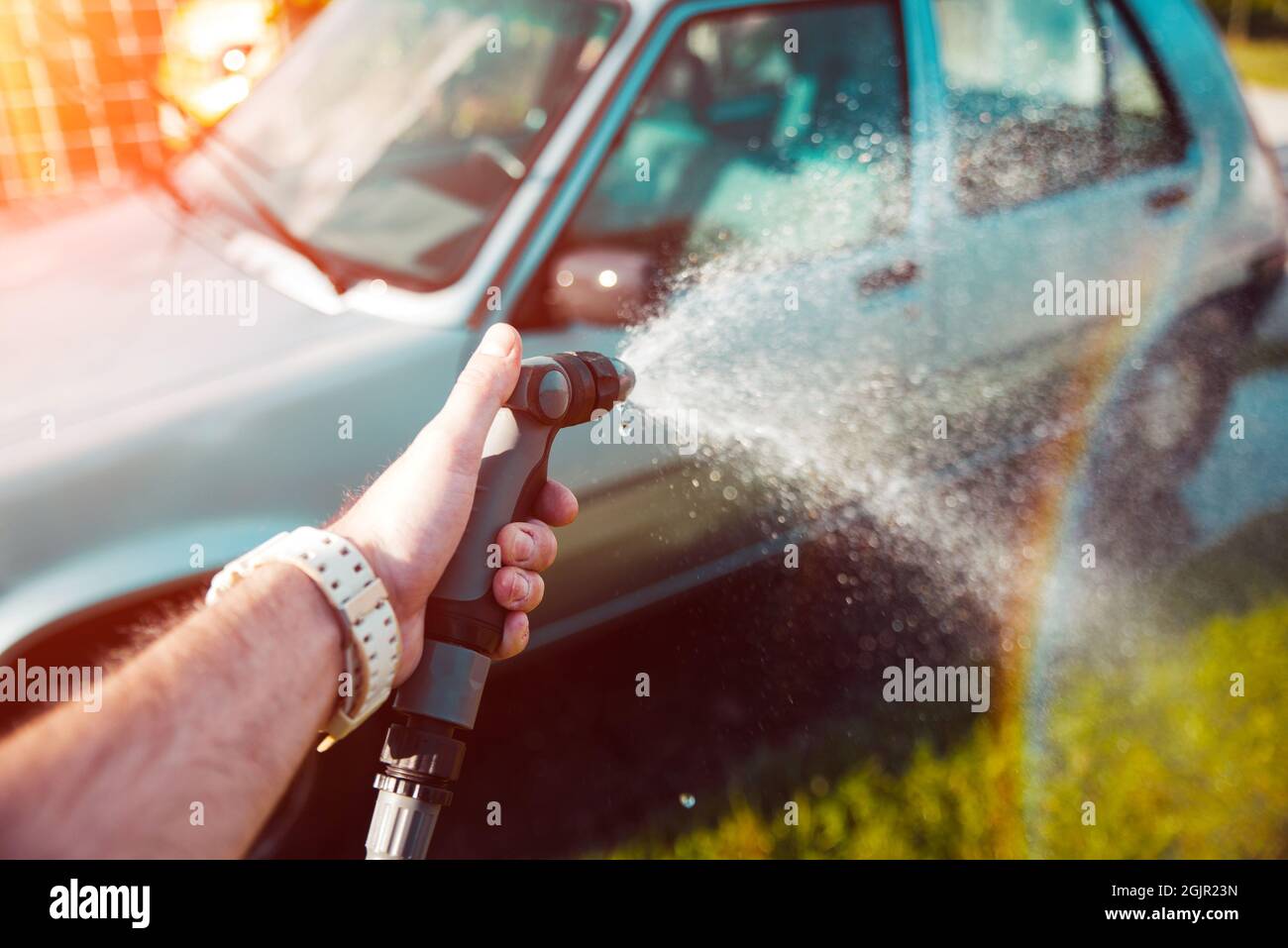 Mano di tenuta acqua spray, lavaggio auto concetto di casa Foto Stock