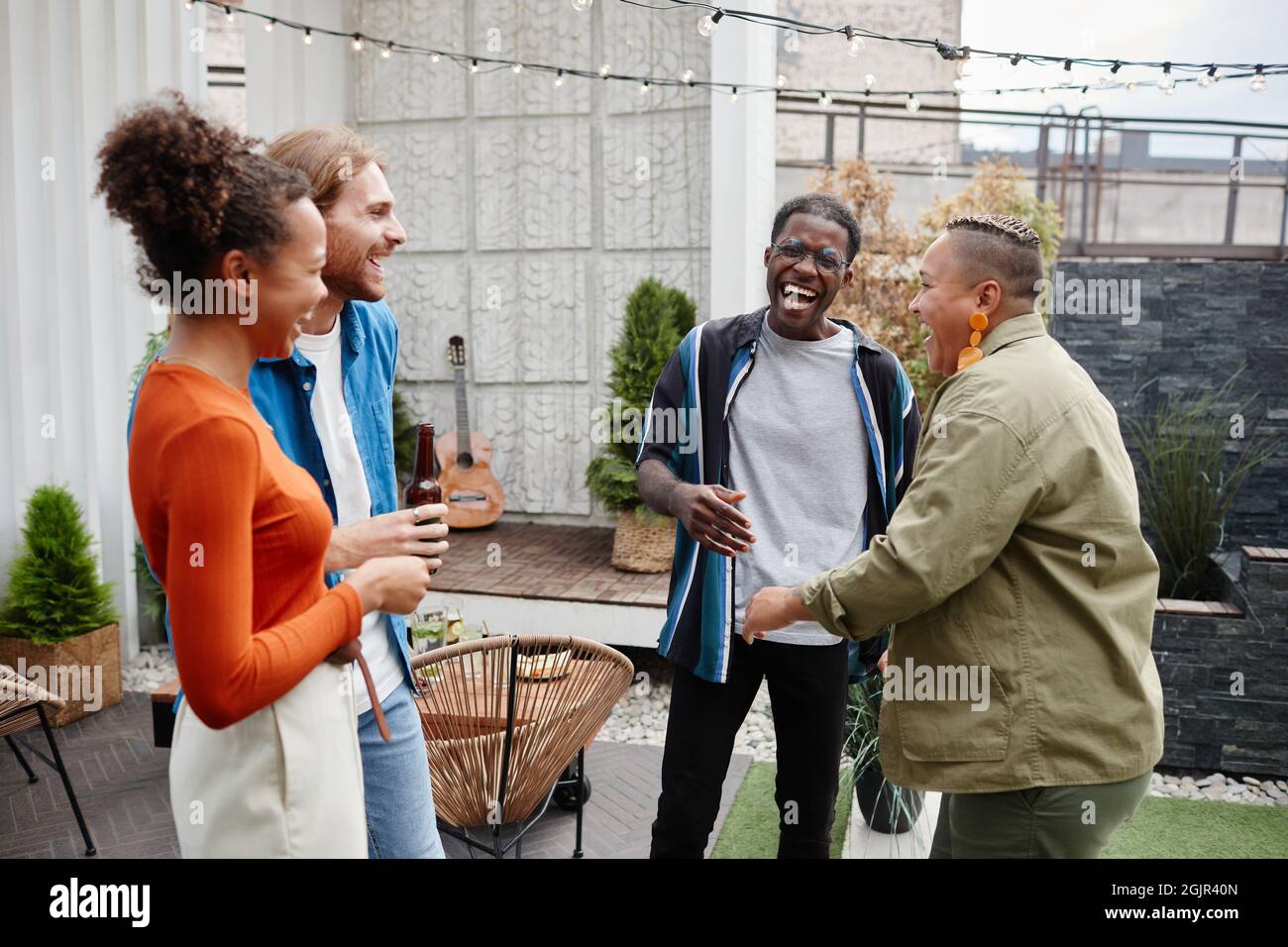 Gruppo diversificato di giovani moderni che si divertono a feste all'aperto sul tetto, spazio per fotocopie Foto Stock