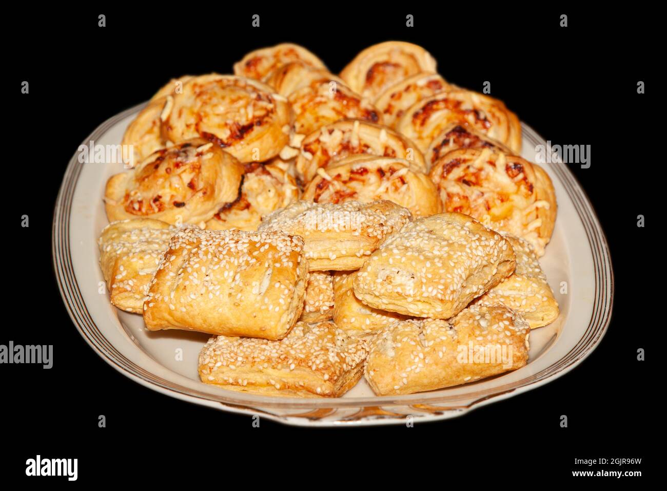 Soffia i dolci con il formaggio dal forno in un piatto bianco, isolato su sfondo nero Foto Stock