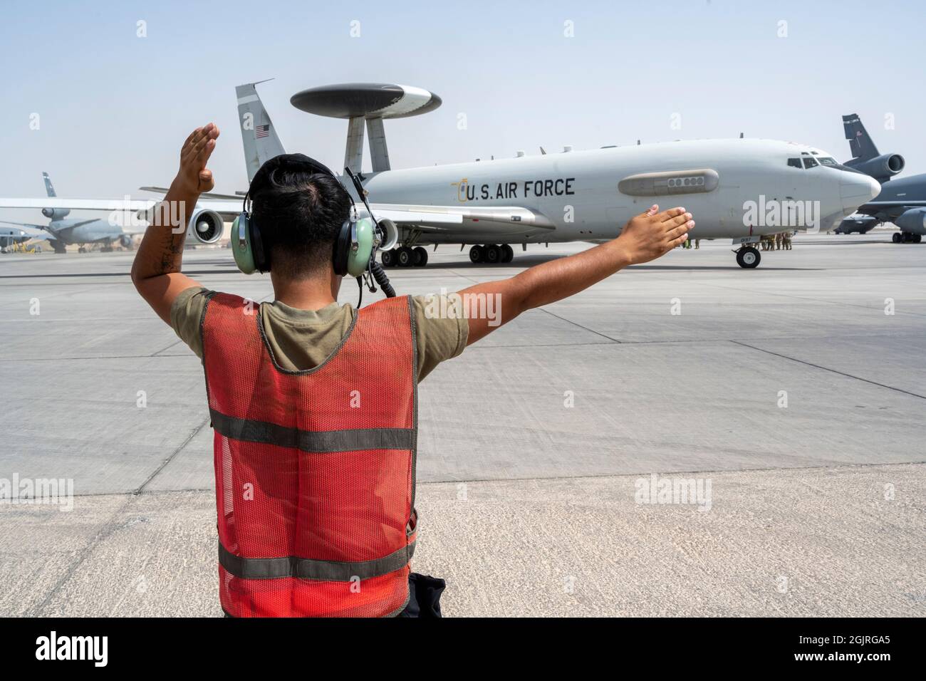 Un Airman dell'aeronautica degli Stati Uniti, con il 380esimo Squadrone di manutenzione dell'aeroplano di Expeditionary, saluta un velivolo e-3 Sentry Airborne di sistema di controllo e di avvertimento mentre si prepara per il decollo dalla base aerea di al Dhafra, Emirati Arabi Uniti a sostegno dell'evacuazione non-combattente, ago 30 2021. Il Dipartimento della Difesa si impegna a sostenere l'evacuazione dei cittadini americani, dei richiedenti speciali visti immigrati e di altri individui a rischio provenienti dall'Afghanistan. (STATI UNITI Air Force foto di Master Sgt. Wolfram M. Stumpf) Foto Stock