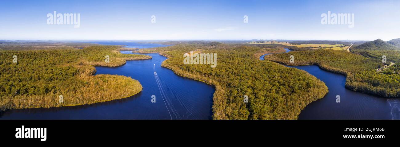 Ampio panorama aereo sui laghi di Myall in Australia verso la costa dell'oceano Pacifico in una giornata di sole - paesaggio panoramico. Foto Stock