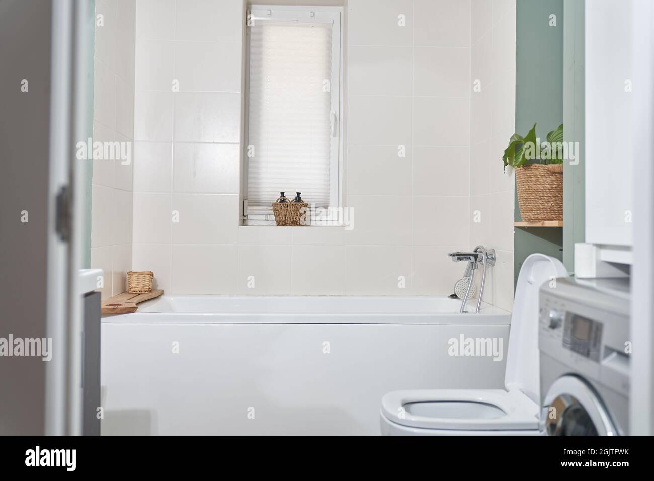 Bel bagno in una nuova casa di lusso. La camera dispone di un elegante bagno, di una lavatrice e di una finestra. Foto di alta qualità Foto Stock