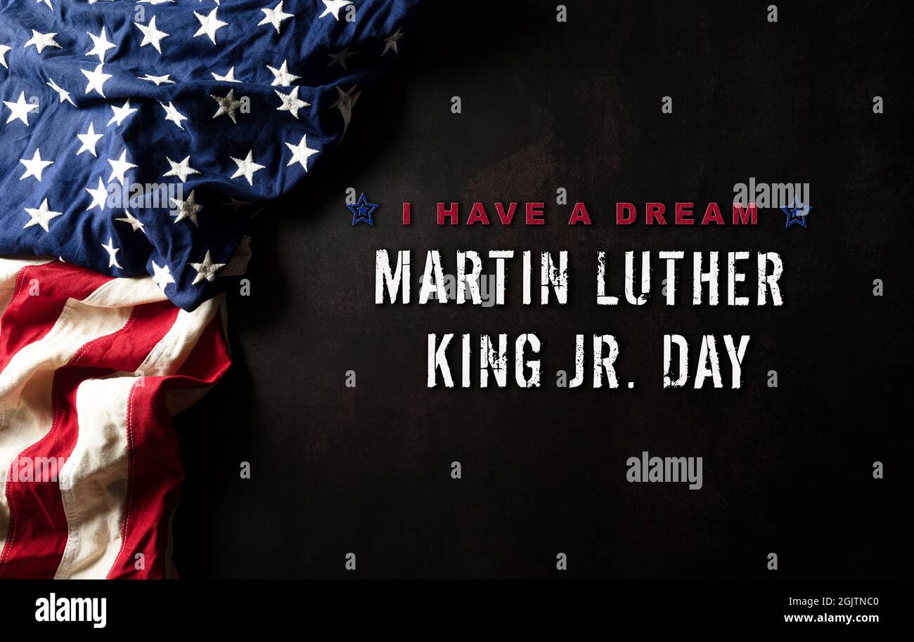 Happy Martin Luther King Day Concept. Bandiera americana sullo sfondo nero in legno Foto Stock