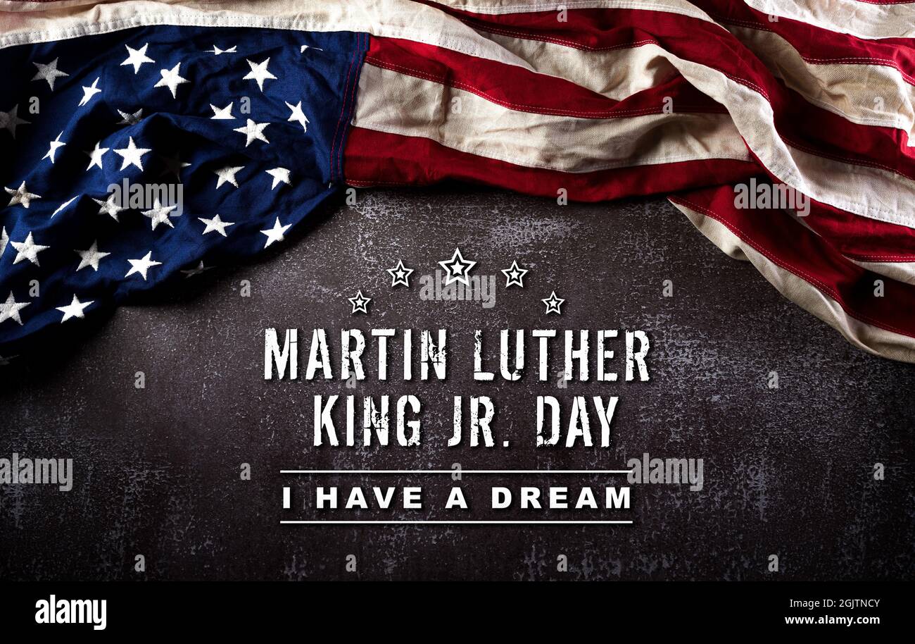 Happy Martin Luther King Day Concept. Bandiera americana contro sfondo di pietra scura Foto Stock