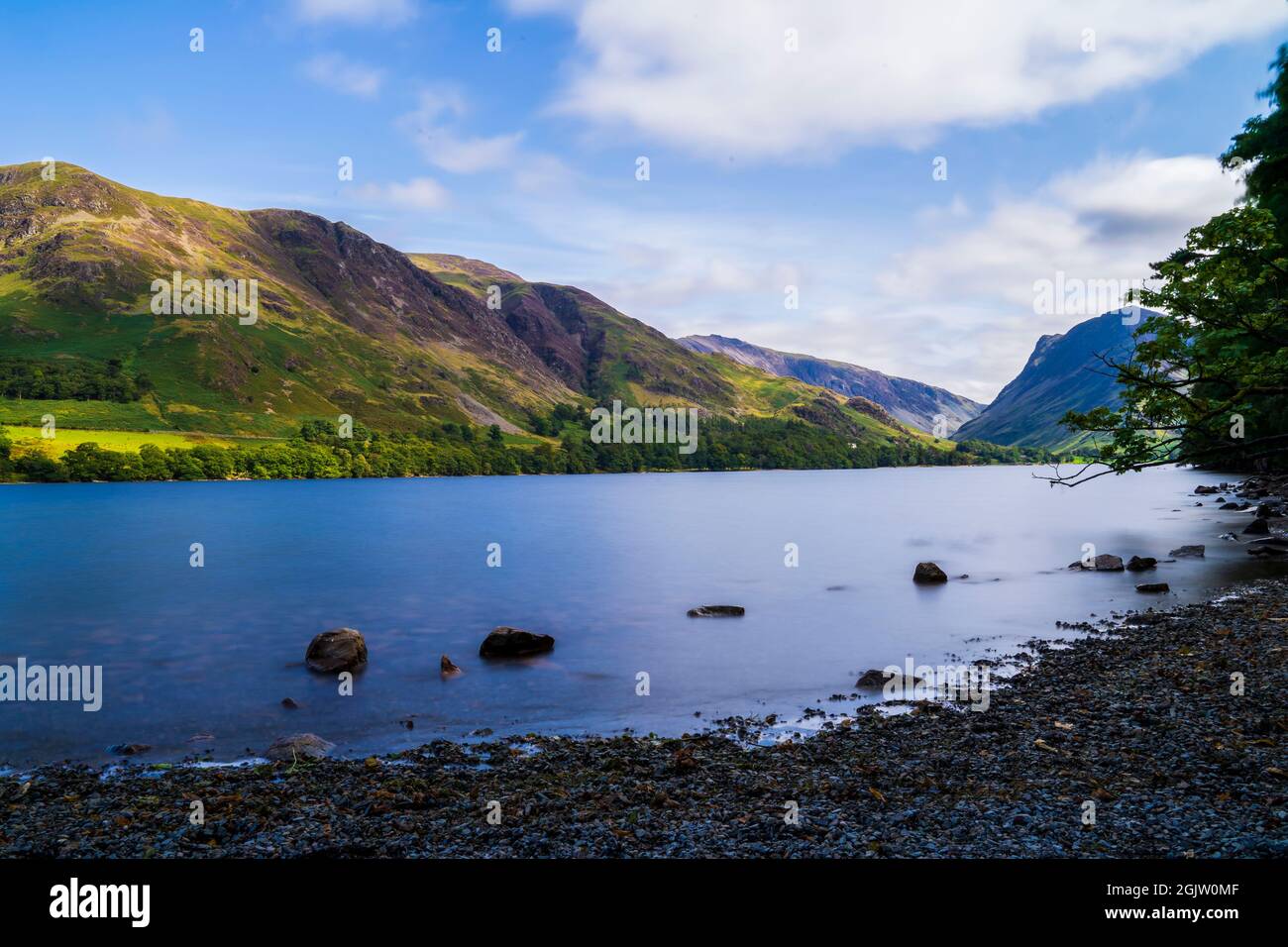 Lungo scatto di esposizione del lago Buttermere in un mezzogiorno d'estate britannico Foto Stock
