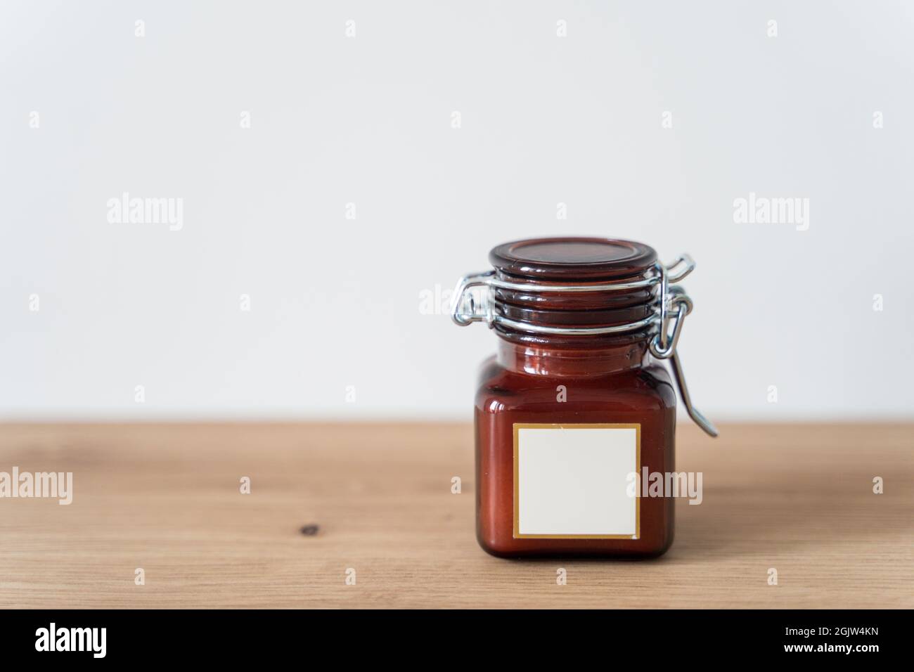 Candela profumata in un vaso di vetro su sfondo bianco Foto Stock