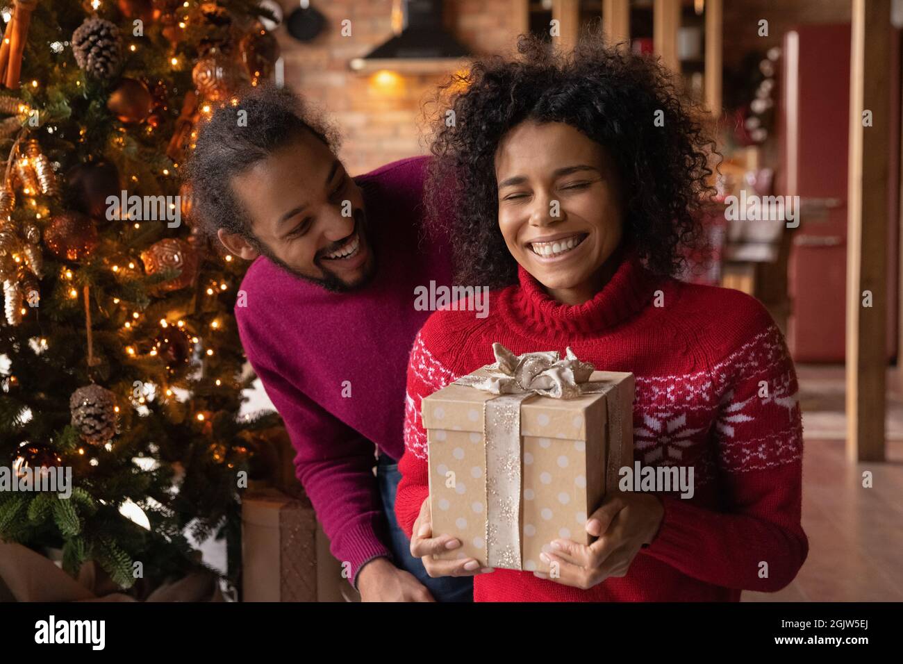 Felice coppia biraciale scambio presenta su Natale Foto Stock