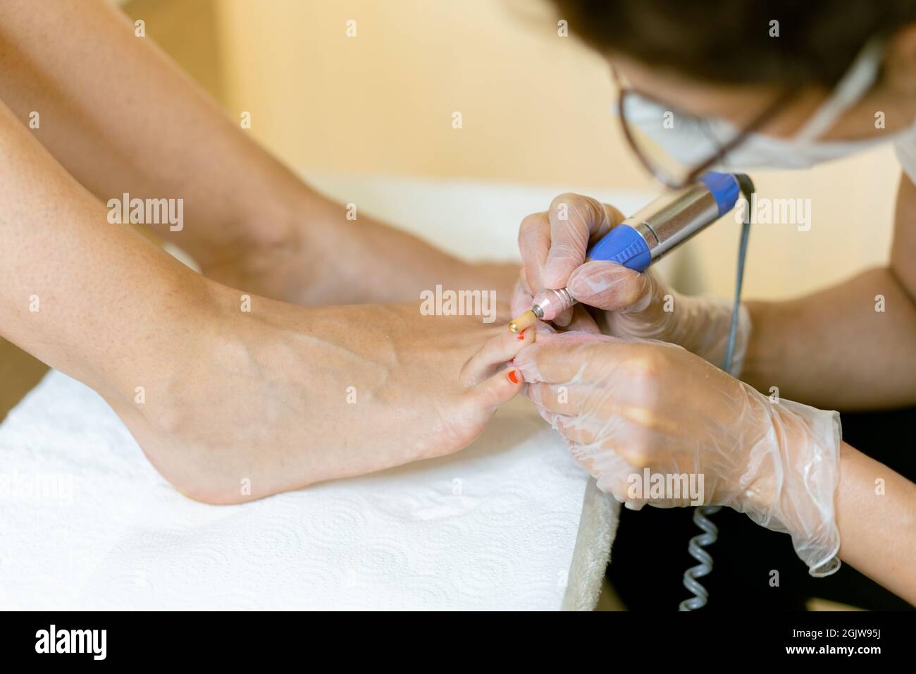 Estetista che dà un pedicure dipingendo le unghie del suo cliente in un centro di bellezza. Foto Stock