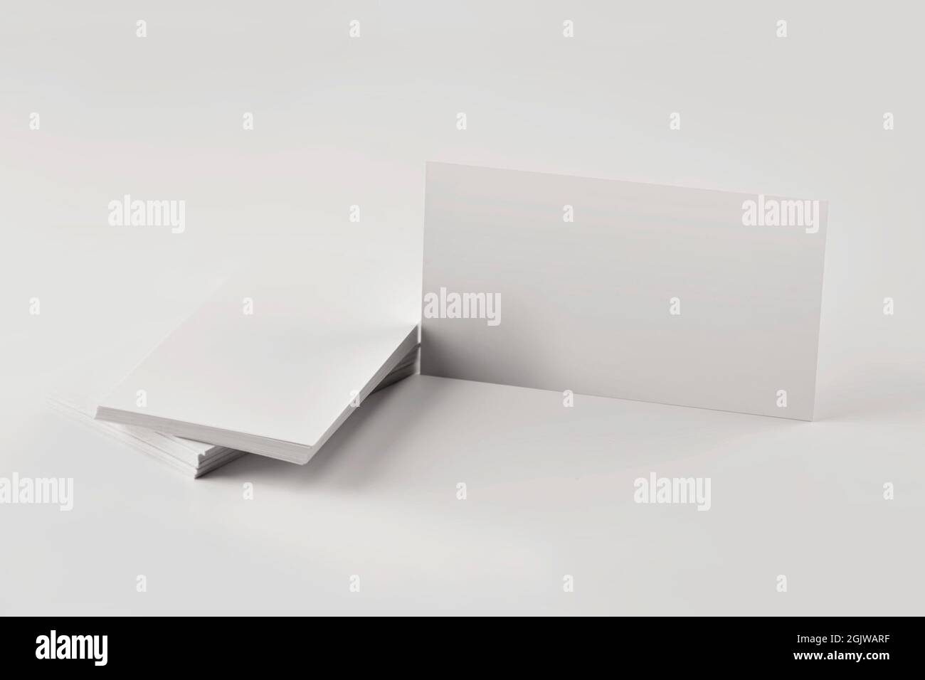 Mockup di una pila di biglietti da visita vuoti su un tavolo grigio primo piano. Foto Stock