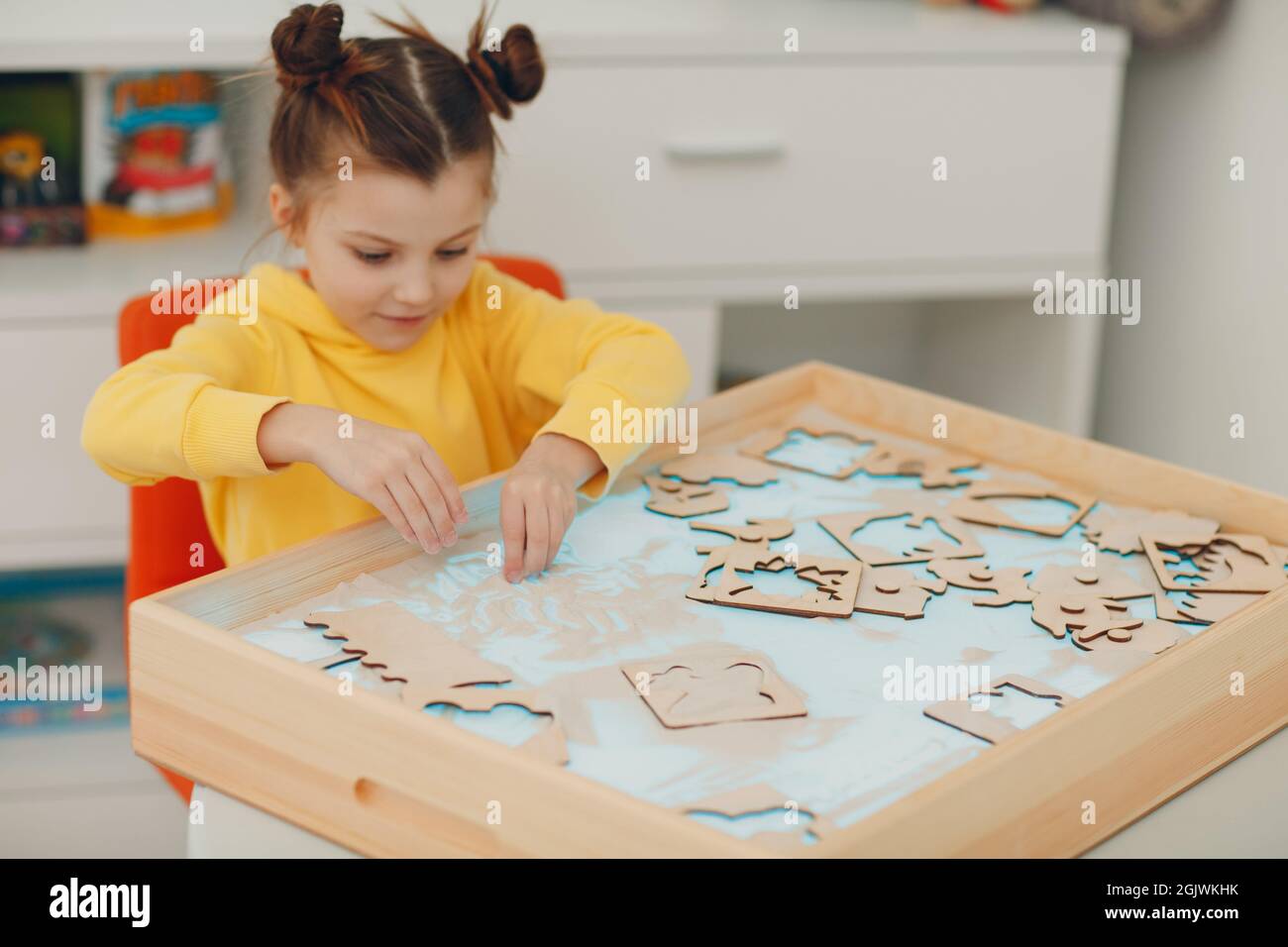 Bambina che gioca con il giocattolo a forma di sabbia. Formazione in età precoce. Concetto di psicologia cognitiva dei bambini piccoli Foto Stock