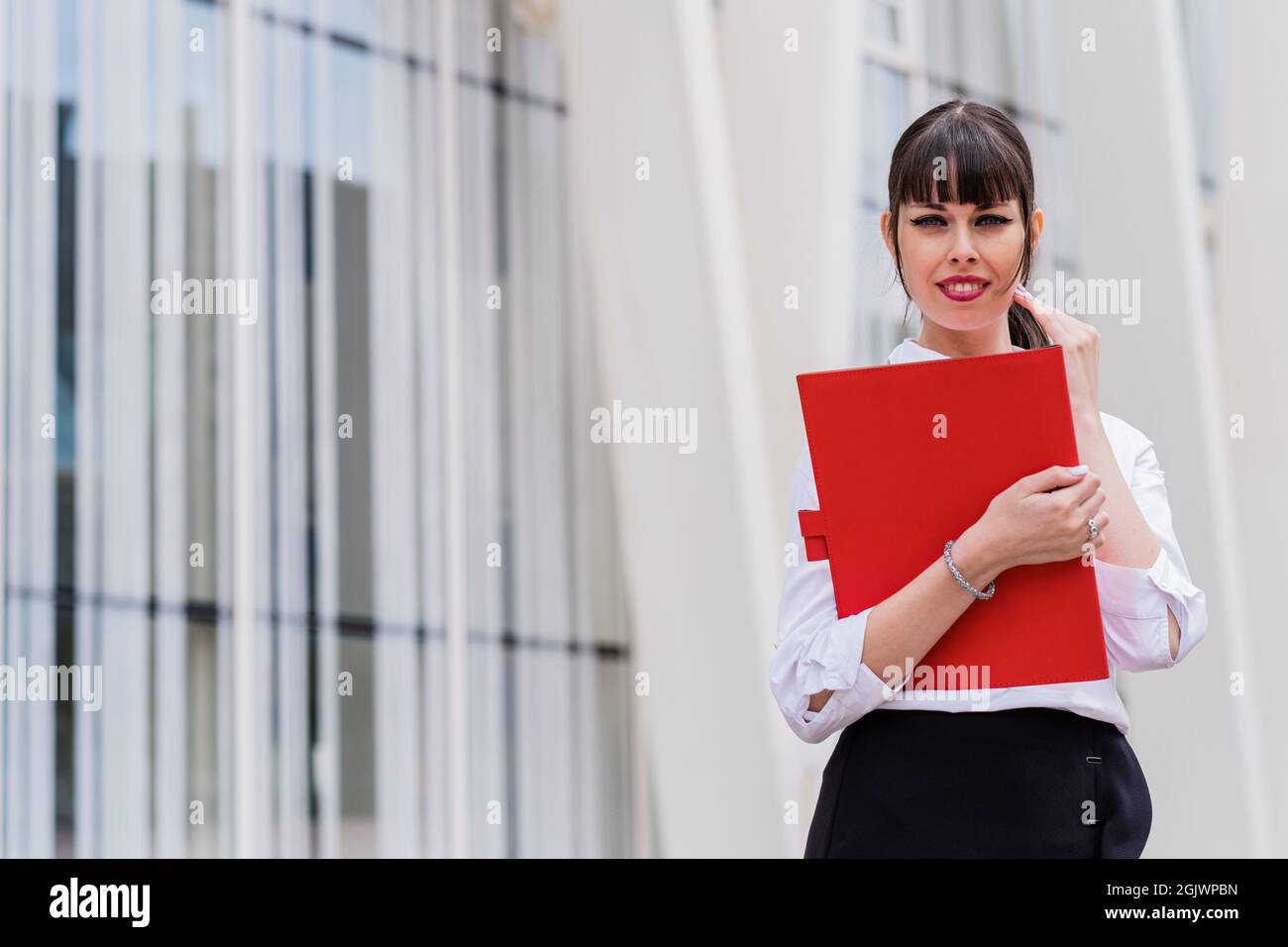 Ritratto di bella donna di affari che tiene il notebook sul suo modo di lavorare Foto Stock