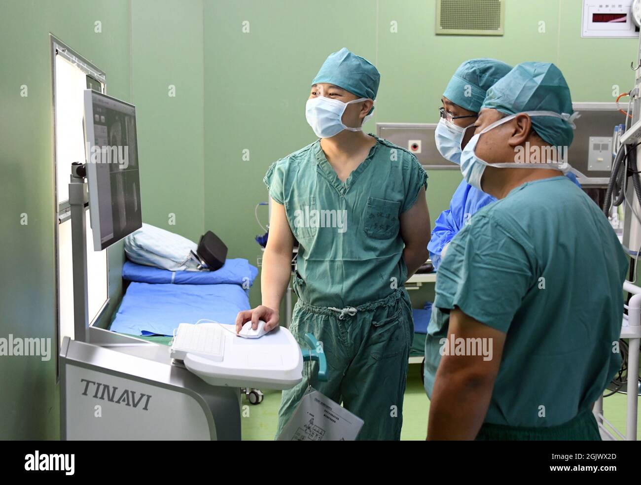 Pechino, Cina. 3 agosto 2021. I medici fanno un piano chirurgico basato sulle informazioni fornite dal robot chirurgico ortopedico in Haidian Hospital, a Pechino, capitale della Cina, 3 agosto 2021. Il robot chirurgico ortopedico può analizzare dinamicamente l'anatomia del paziente e la relazione colonna-anca ed eseguire la pianificazione chirurgica personalizzata esattamente come pianificato. L'ospedale Haidian di Pechino ha introdotto ufficialmente robot di chirurgia ortopedica a partire dal maggio 2020, e ha completato più di 400 interventi chirurgici robotici entro la fine di agosto 2021. Credit: Ren Chao/Xinhua/Alamy Live News Foto Stock