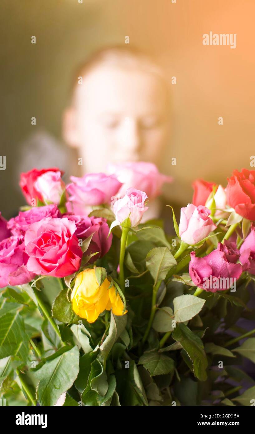 Bella ragazza con un bouquet di fiori rosa, rossi e gialli. Foto Stock
