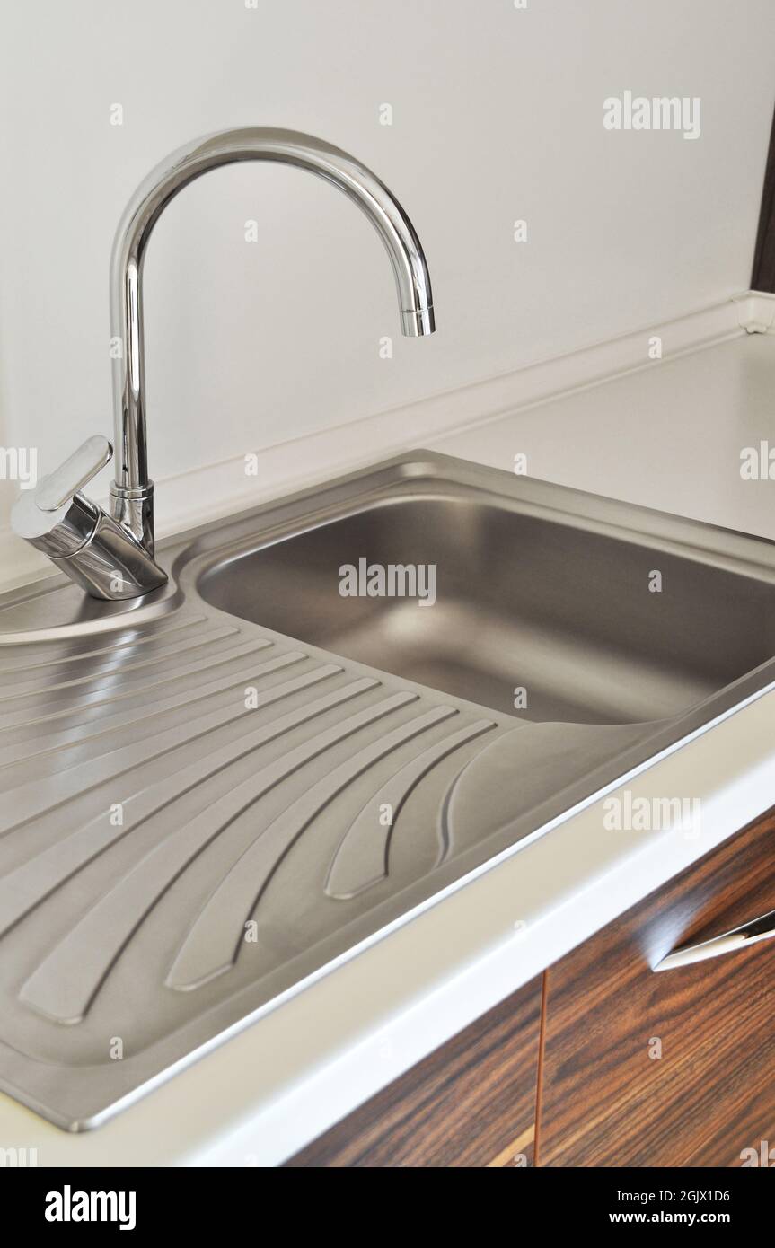 Interno di lussuosa cucina moderna e lavandino, rubinetto e scarico in acciaio inossidabile Foto Stock