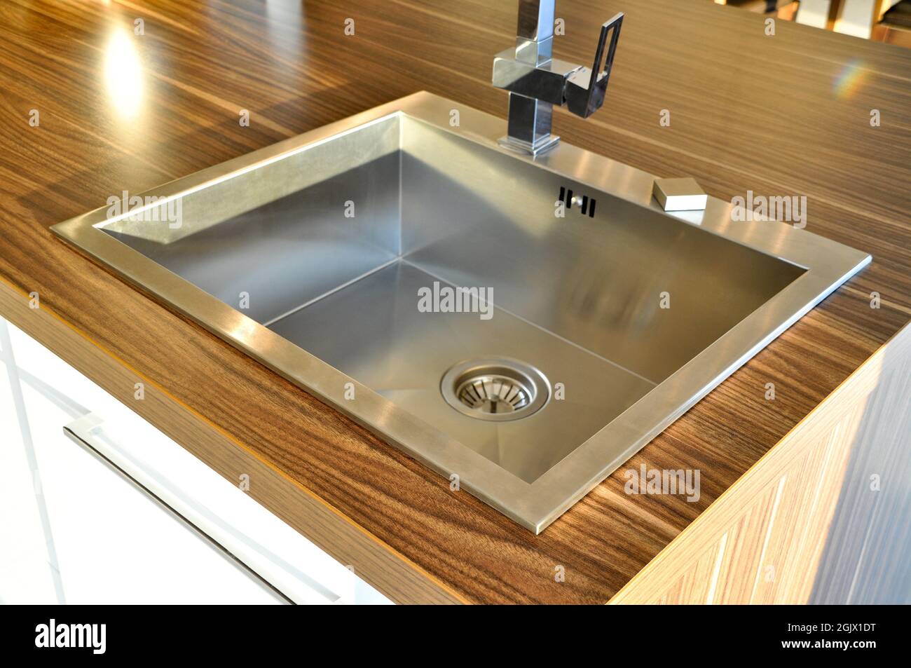 Interno di lussuosa cucina moderna e lavandino, rubinetto e scarico in acciaio inossidabile Foto Stock