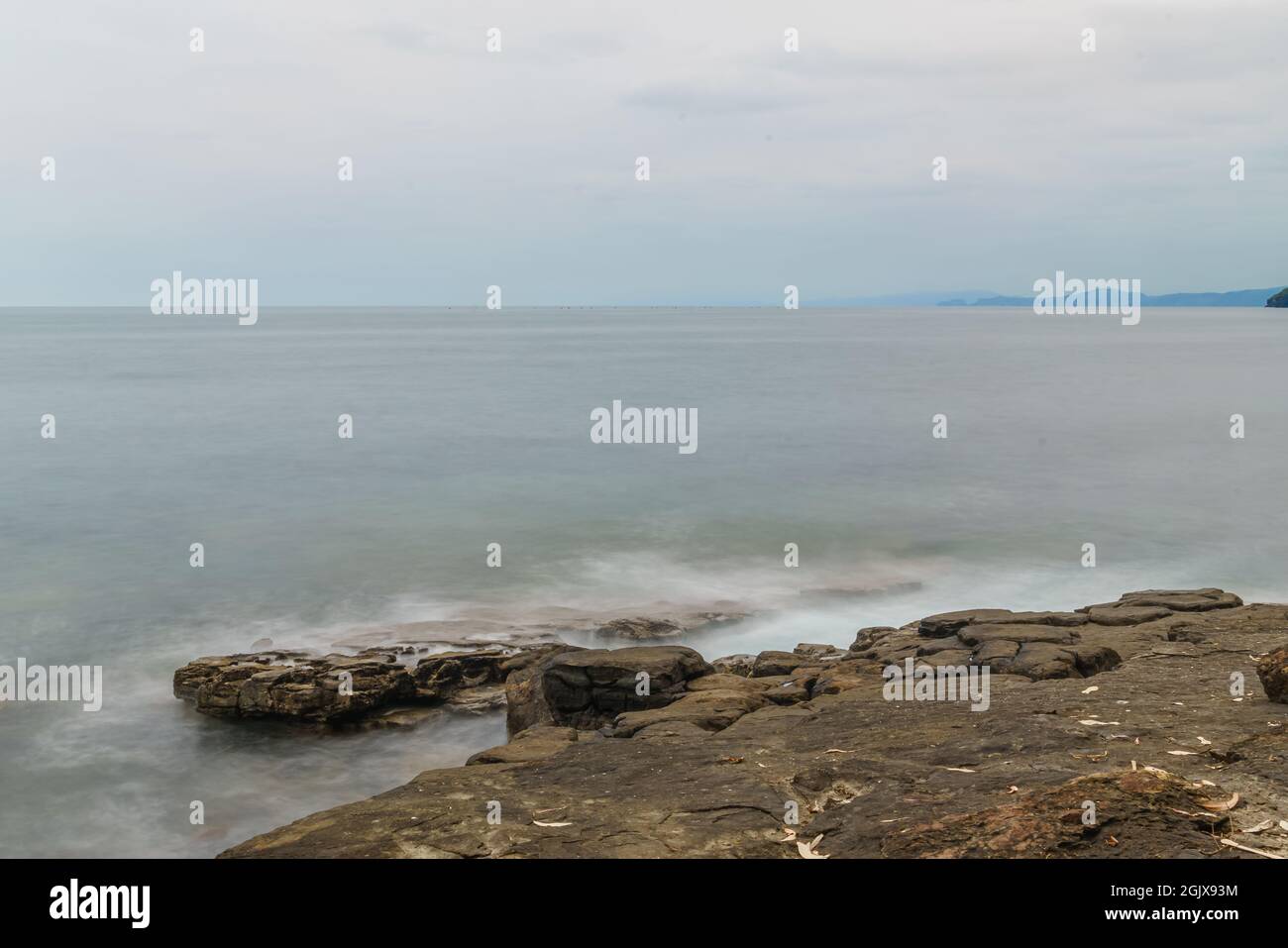 Onde che colpiscono sulla roccia Foto Stock