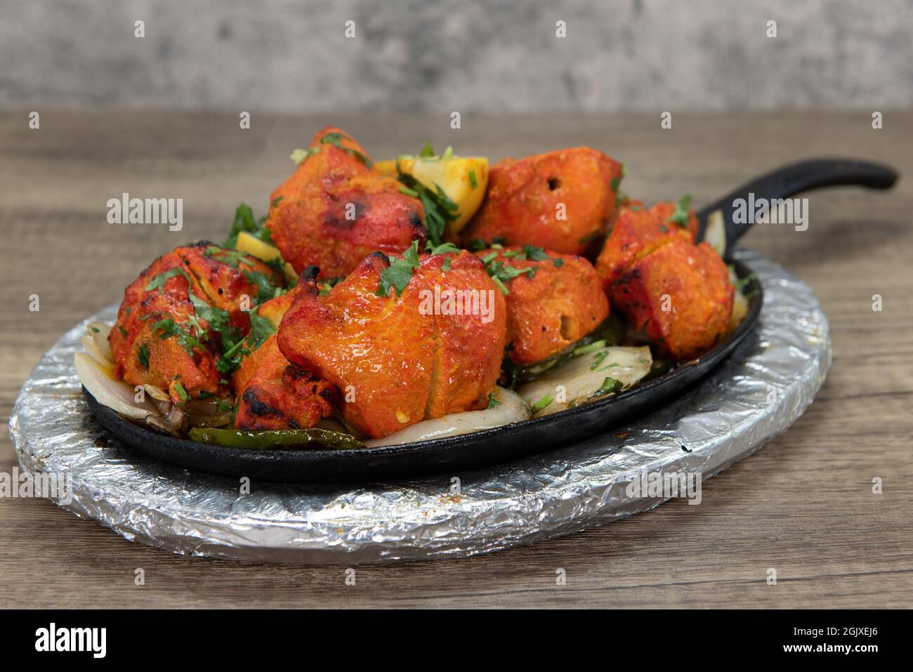 Pollo condito servito sulla padella del ristorante indiano cucinato e condito perfettamente. Foto Stock