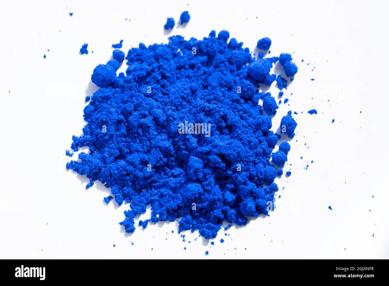 Primo piano di una porzione di pigmento blu isolato su bianco visto dall'alto. Il pigmento sarà mescolato con olio di lino per fare vernice di olio Foto Stock