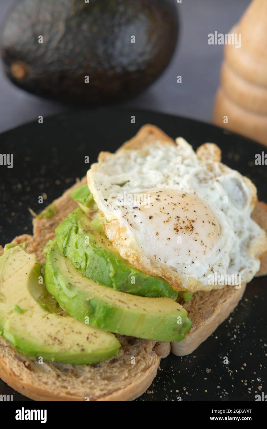 Avocado, pane marrone, uova e rosmarino sul tavolo Foto Stock