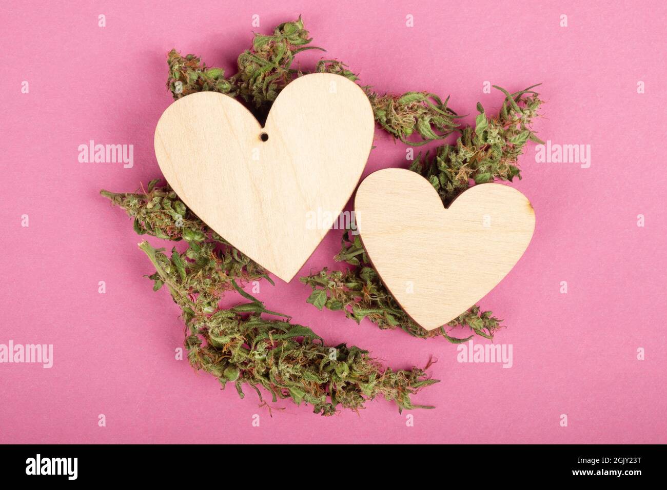 giornata di san valentino con cuori di legno di marijuana e cannabis ricreativa. Foto Stock