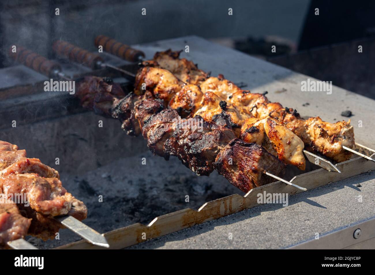 carne fritta in grandi pezzi grigliati barbecue shahlyk kebab fumo all'aperto street food Foto Stock