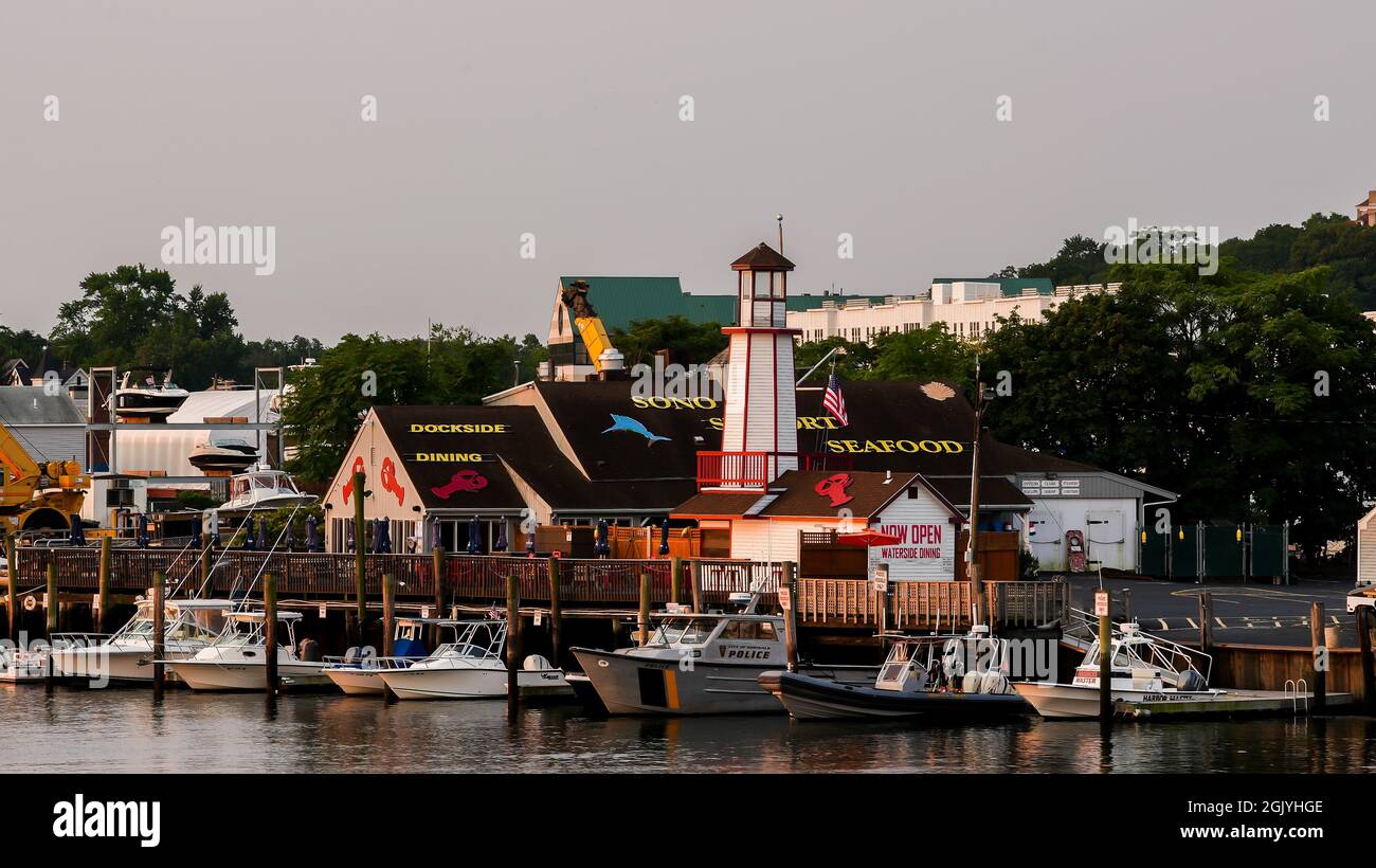 NORWALK, CT, USA - 12 SETTEMBRE 2021: Ristorante Waterside Dinning con bella luce dell'alba e barche attraccano nel fiume Norwalk vicino al centro Foto Stock