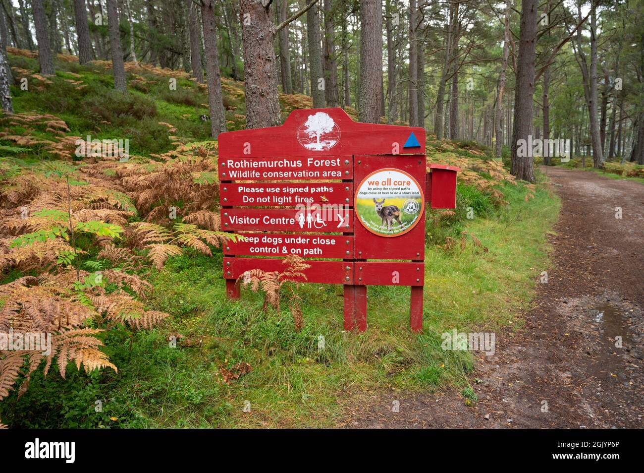Insegna rossa e bianca per Rochiemurchus Forest Wildlife Conservation Area nel Cairngorms National Park. Percorso e sfondo offuscato foresta. Foto Stock