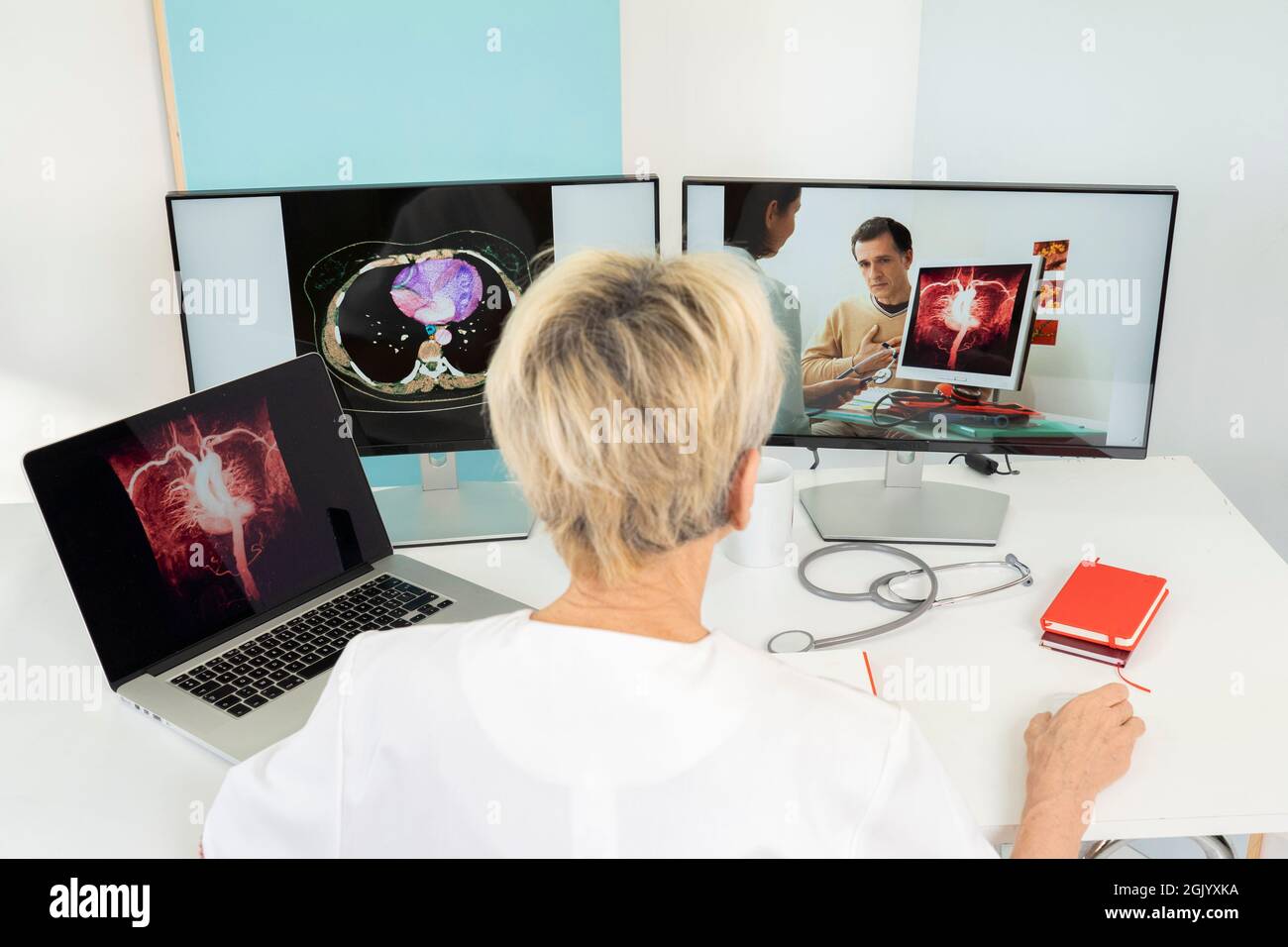 Teleconsulto tra due medici con immagini mediche del cuore su schermi. Foto Stock