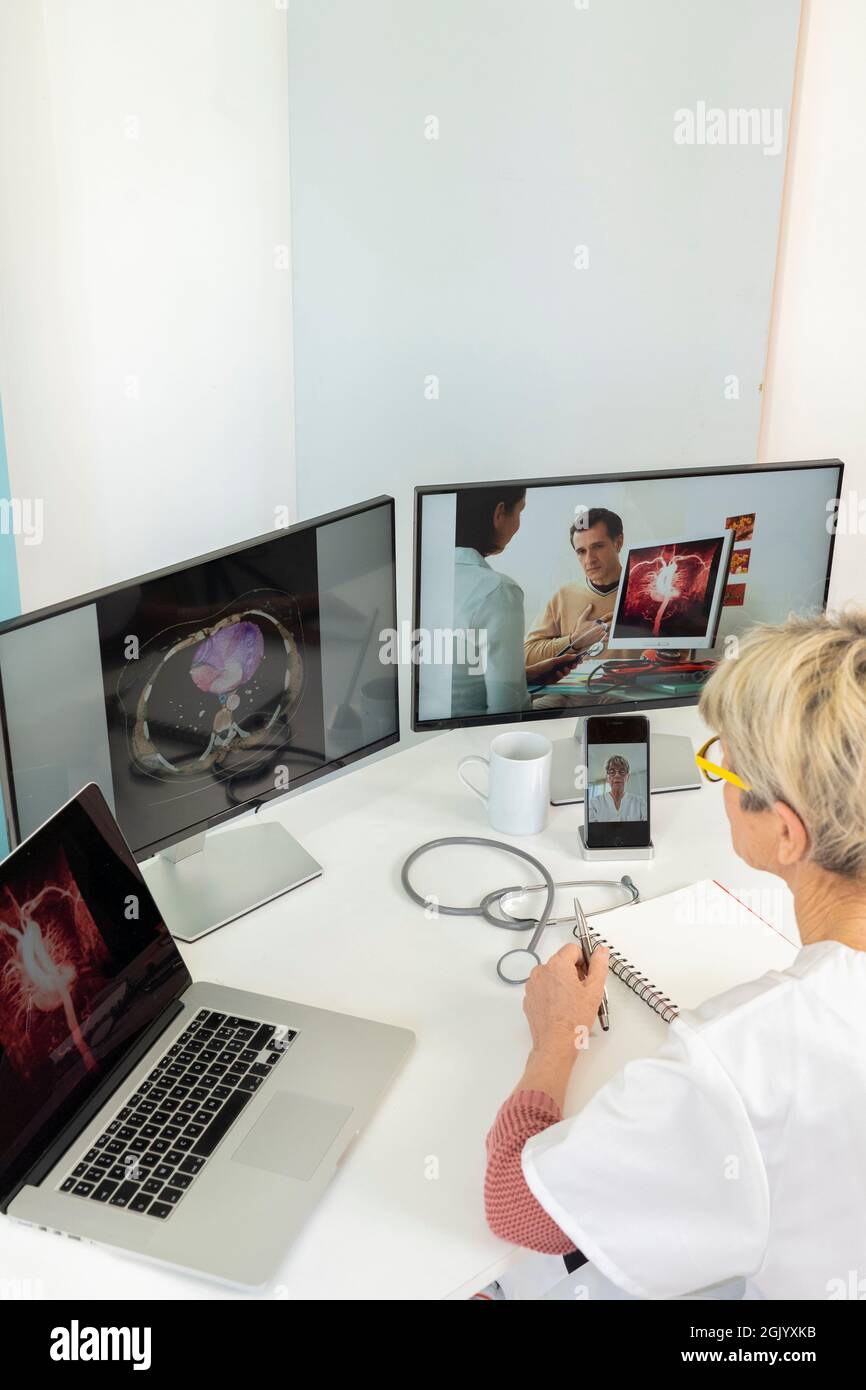 Teleconsulto tra due medici con immagini mediche di stomaci su uno degli schermi. Foto Stock