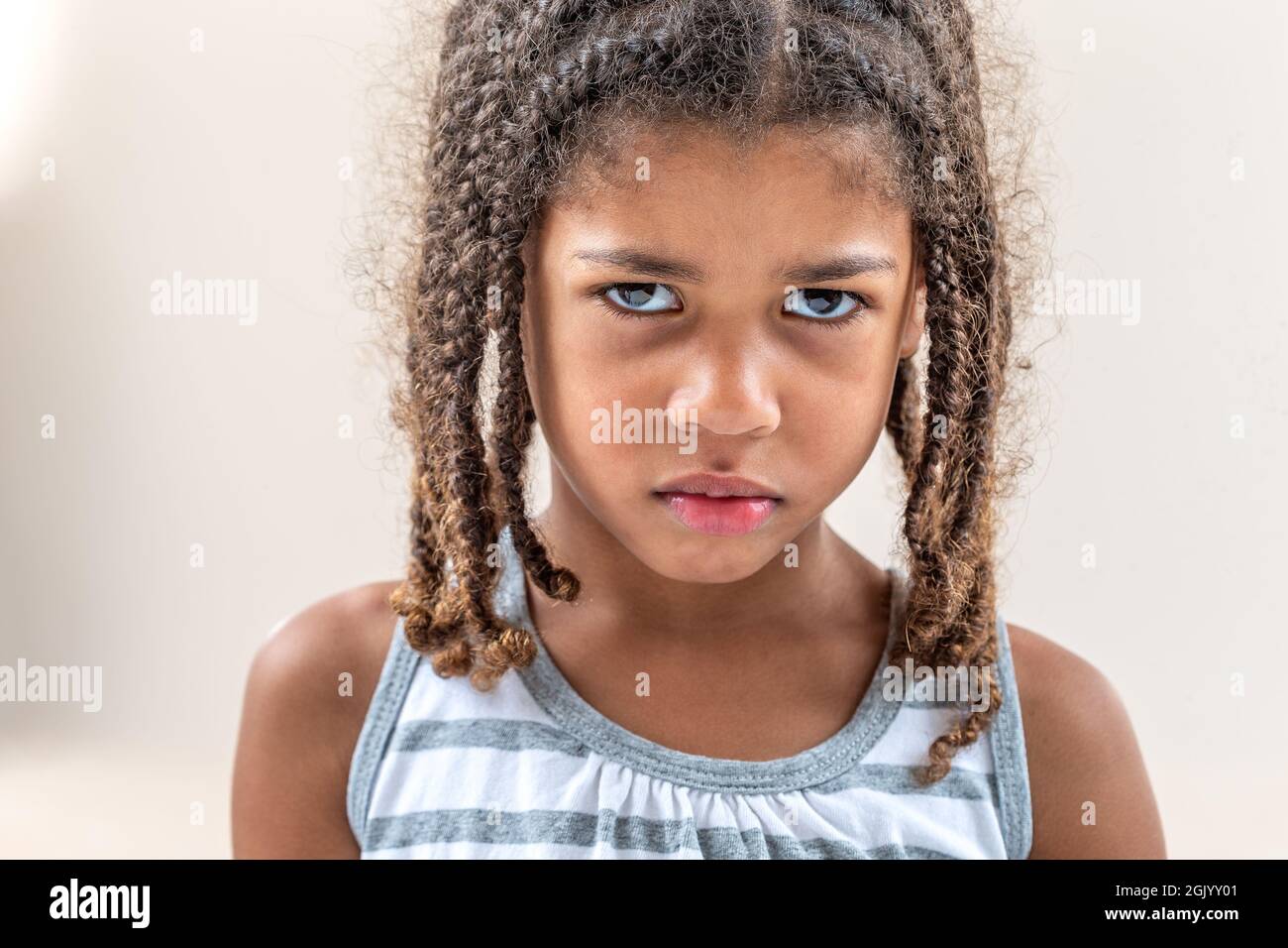 Bambina che fa le espressioni facciali faccia su bianco Foto Stock