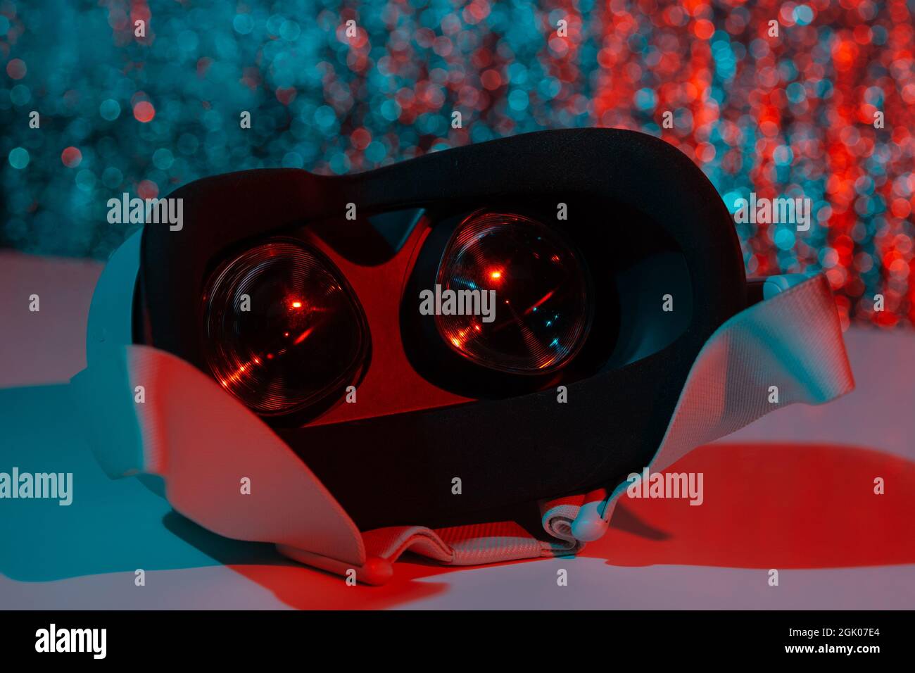 Casco per realtà virtuale su sfondo bianco con luce al neon. Realtà virtuale, futuro, gadget, concetto di tecnologia. Foto Stock