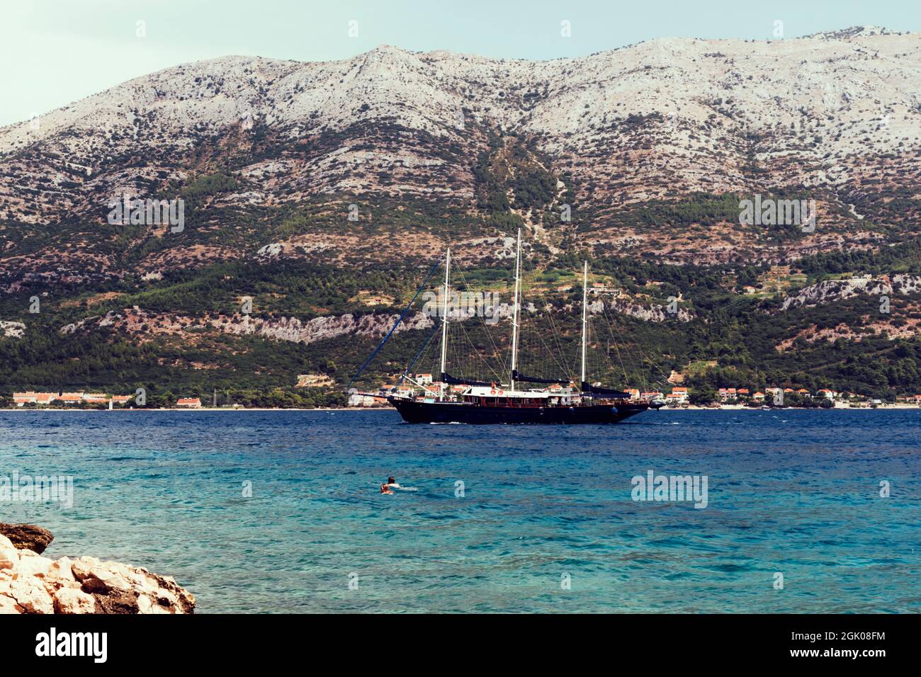 La nave naviga lungo la riva con le montagne. Foto Stock