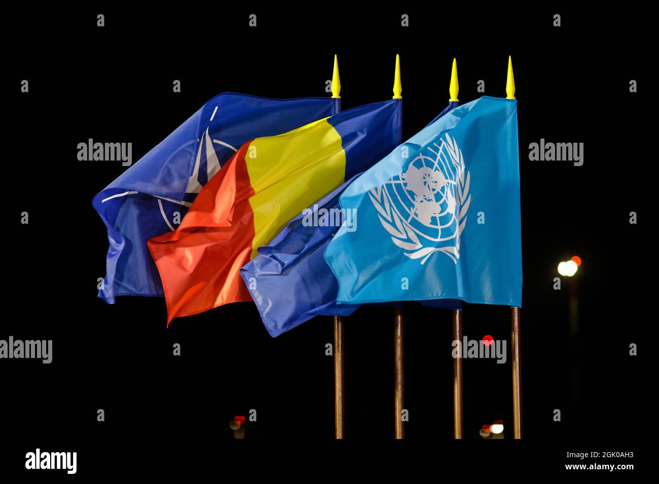 Otopeni, Romania - 9 settembre 2021: La NATO, la Romania, l'Unione europea e le Nazioni Unite battono il vento di notte. Foto Stock