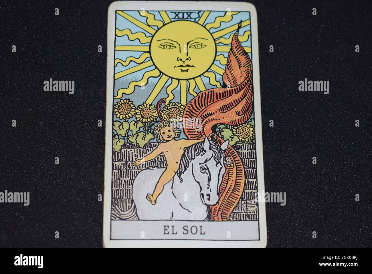 La carta Tarocchi numero 19 rappresenta IL SOLE nelle carte tarocchi degli arcani maggiori su sfondo nero. Foto Stock