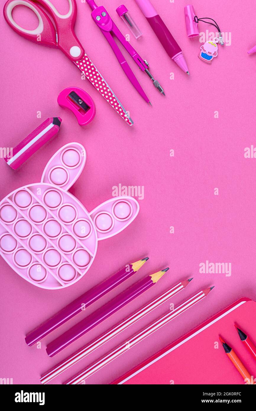 Cartoleria rosa su sfondo rosa. Concetto creativo di ritorno a scuola.  pfoto verticale. Disposizione piatta Foto stock - Alamy