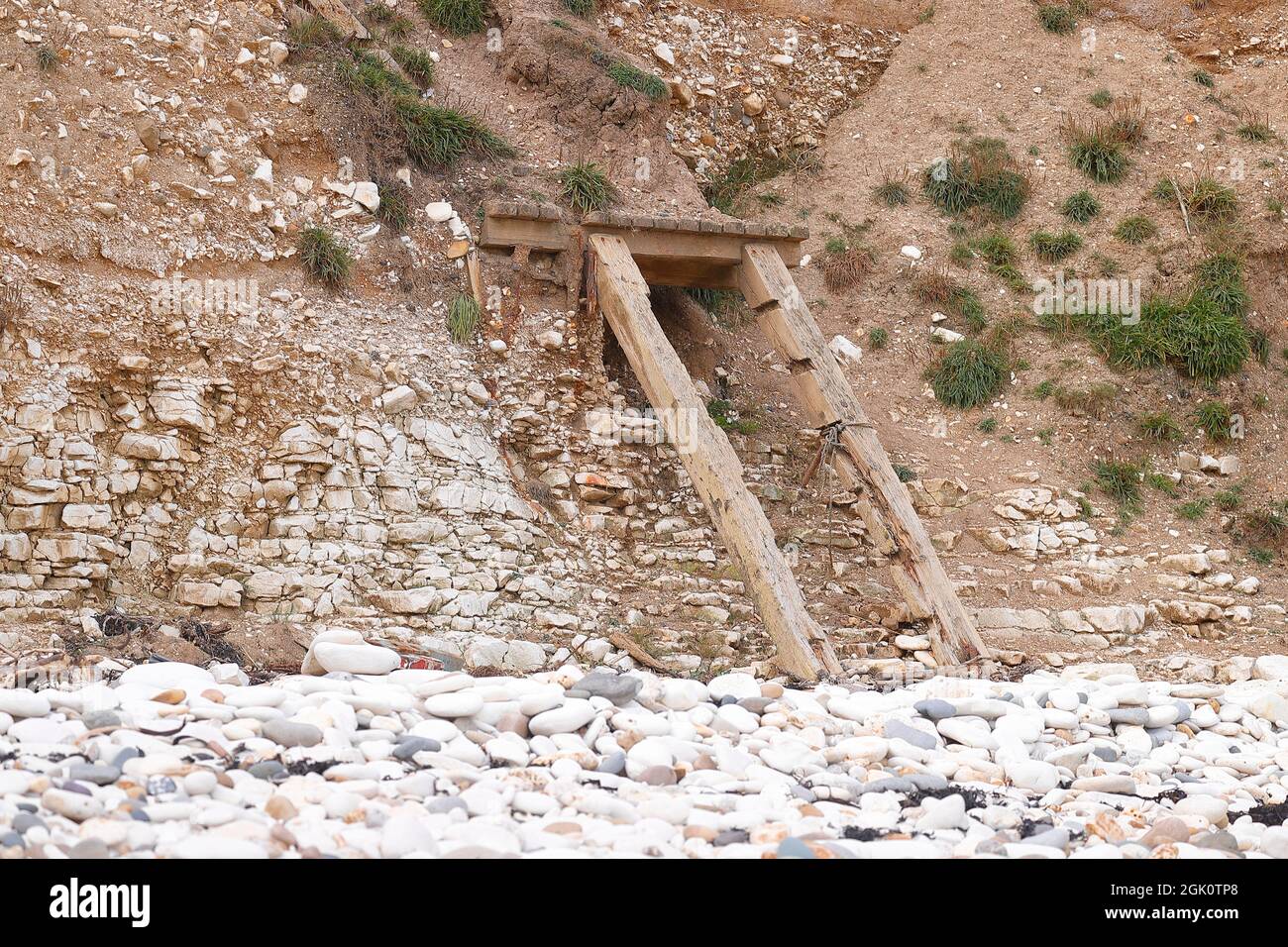 Travi che una volta erano parte di gradini che hanno permesso l'accesso alla spiaggia a Flamborough sono tutti che rimangono a causa di erosione costiera. Foto Stock