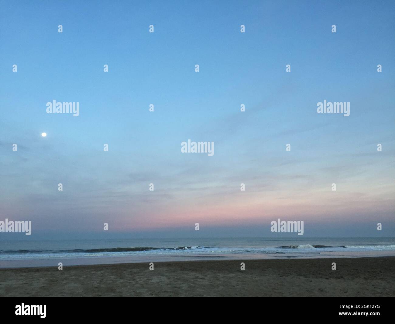 Tranquillo paesaggio di spiaggia al crepuscolo con luna crescente Foto Stock